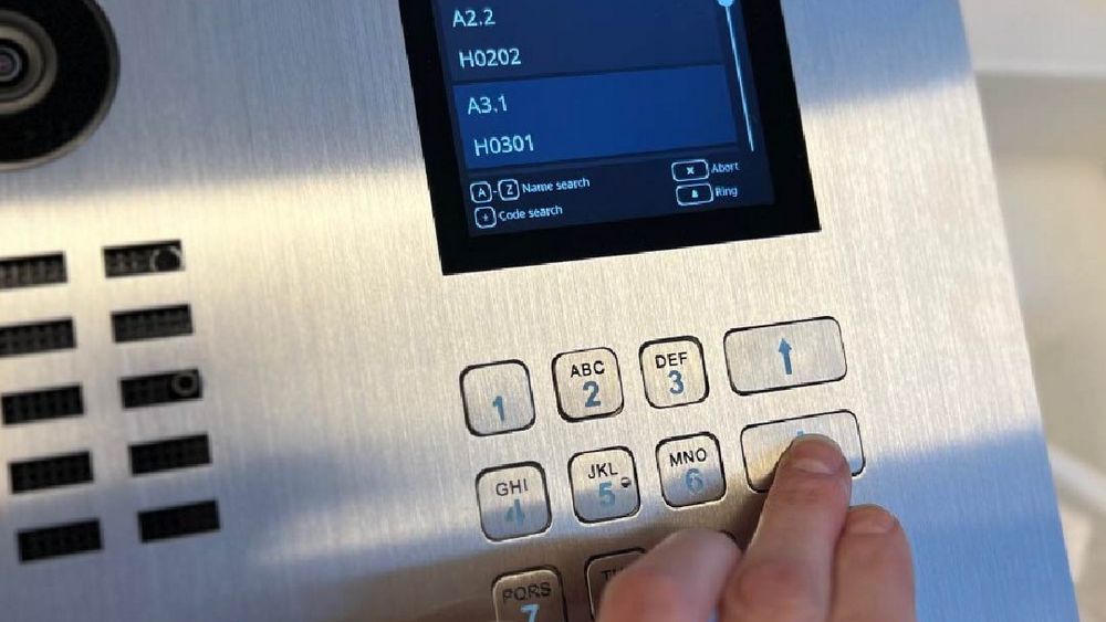 Porttelefon Doorbird med overflate i børstet stål og med kamera, monitor og knapper.